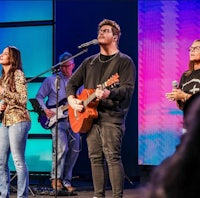 a group of people singing in front of a microphone