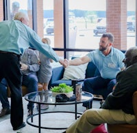 a group of people shaking hands in a lobby