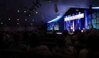 a group of people sitting in a church auditorium