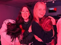 a group of girls hugging each other in a dark room