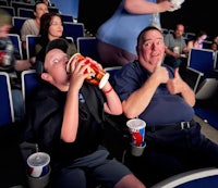 a group of people sitting in a theater watching a movie