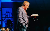 a man holding a book in front of a stage